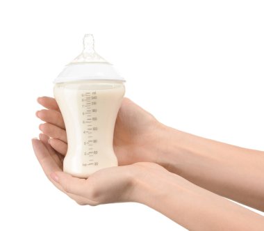 Beyaz arka planda bebek için süt şişeli kadın elleri
