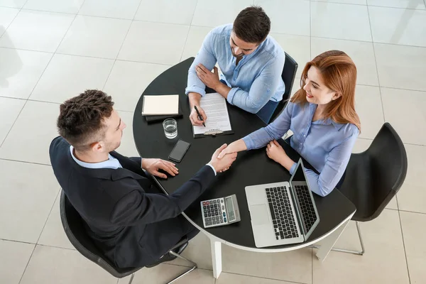 Bank manager and clients shaking hands in office — Stock Photo, Image