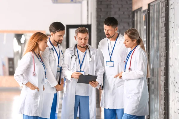 Portrait of doctors discussing diagnosis in corridor of modern clinic — Stock Photo, Image