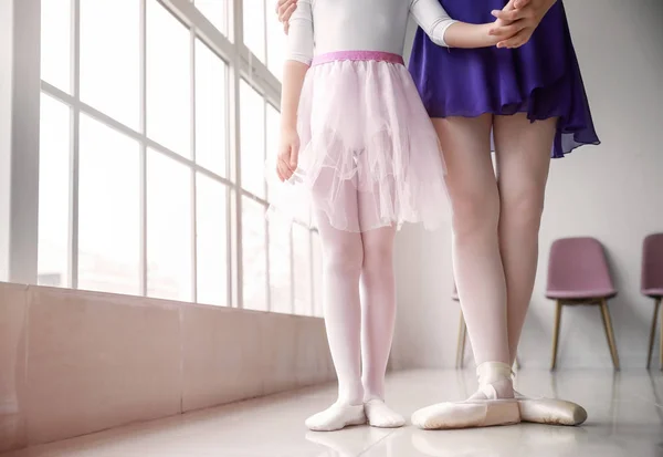 Little ballerina training with coach in dance studio