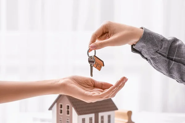 Real estate agent giving a key from new house to client in office — 스톡 사진