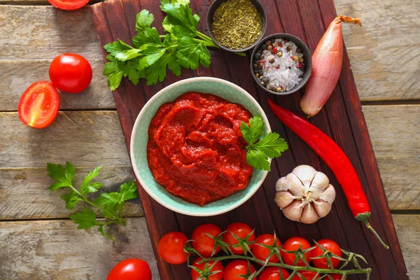 Cuenco con salsa de tomate e ingredientes en la mesa — Foto de Stock