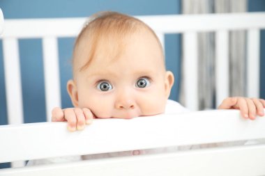 Beşikte oturan şirin bebek.