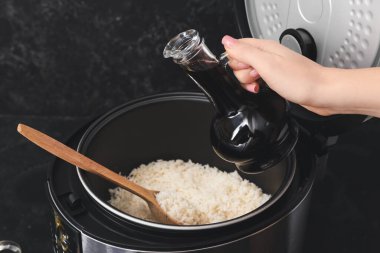 Woman preparing tasty rice in multicooker