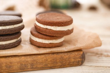 Board with tasty chocolate cookies on white table, closeup