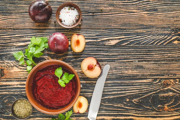 Bowl with plum sauce and ingredients on table — Stock Photo, Image