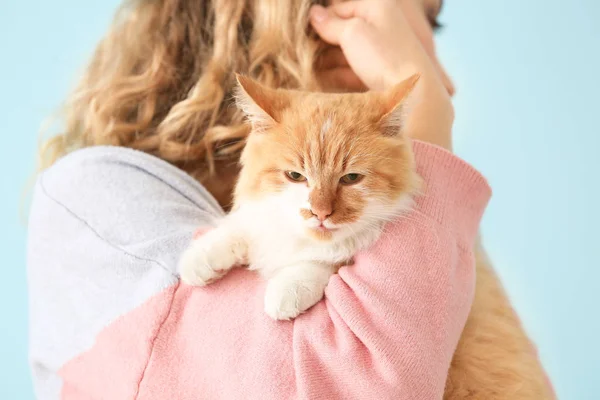 Красивая молодая женщина с милым котом на цветном фоне — стоковое фото