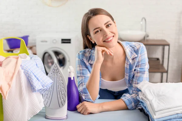 Linda jovem dona de casa com lavanderia em casa — Fotografia de Stock