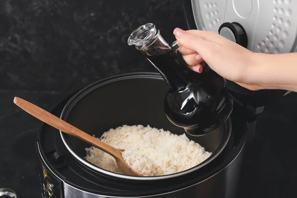 Mujer preparando sabroso arroz en multicooker —  Fotos de Stock