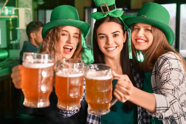 Jonge vrouwen met bier vieren St. Patrick 's Day in de pub — Stockfoto