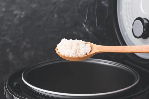 Spoon with boiled rice on dark background — Stok fotoğraf