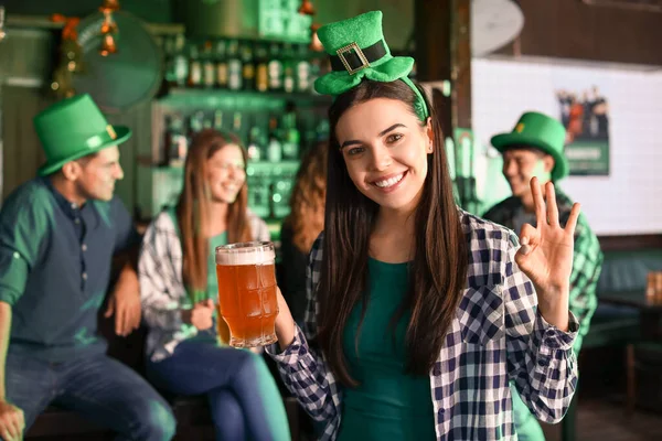 Jonge vrouw met bier viert St. Patrick 's Day in pub — Stockfoto