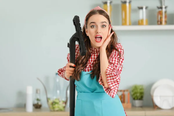 Funny housewife with vacuum cleaner in kitchen — Stok fotoğraf