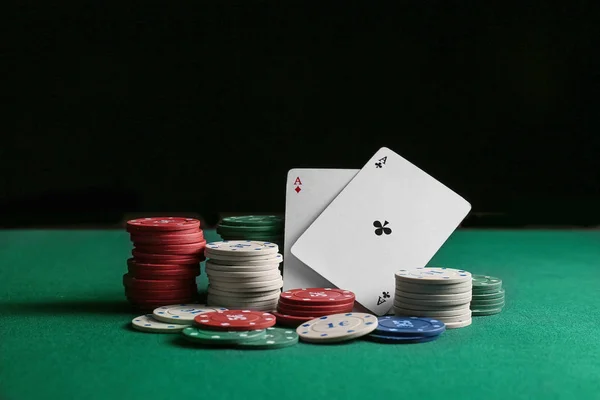 Chips and playing cards for gambling games on table in casino