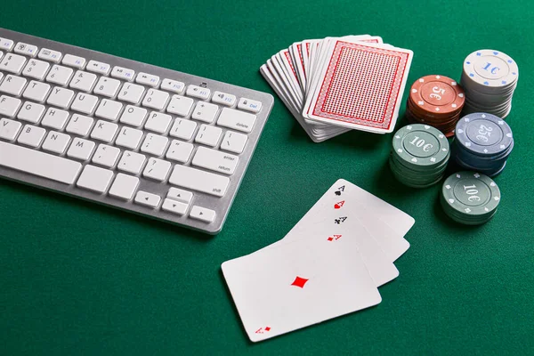 Chips and playing cards for gambling games with computer keyboard on color background — Stock Photo, Image