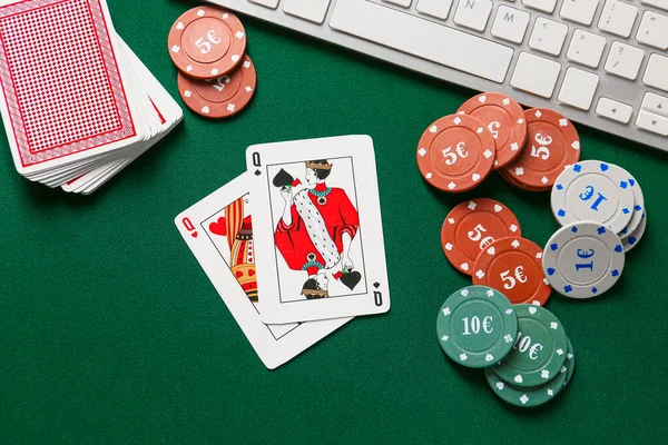 Chips and playing cards for gambling games with computer keyboard on color background — Stock Photo, Image