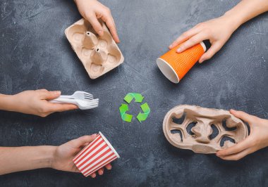 Hands with garbage on dark background. Concept of recycling
