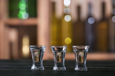 Glasses of vodka on table in bar. Concept of alcoholism