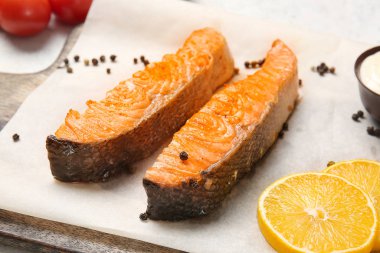 Board with tasty cooked salmon, closeup