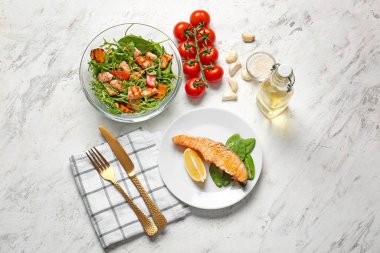 Beyaz arka planda somon balığı olan lezzetli yemekler.