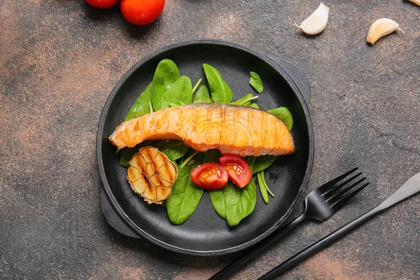 Frying pan with tasty cooked salmon on dark background — Stock Photo, Image