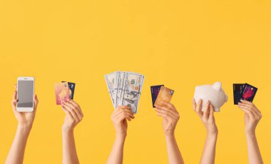 Parası, kredi kartları, kumbarası ve renkli cep telefonu olan kadın elleri. Çevrimiçi bankacılık kavramı