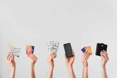Paralı, kredi kartlı, cep telefonlu, cüzdanlı ve ışıklı arka planda alışveriş arabalı kadınlar. Çevrimiçi bankacılık kavramı