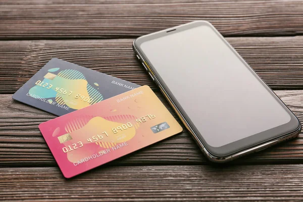 Hitelkártya mobiltelefonnal fából készült háttérrel. Az online banki tevékenység fogalma — Stock Fotó