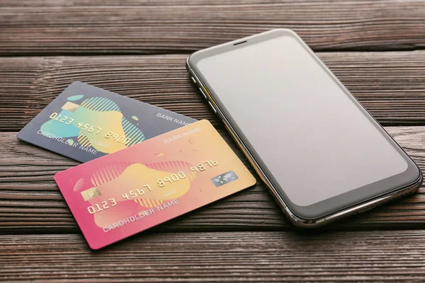 Credit cards with mobile phone on wooden background. Concept of online banking