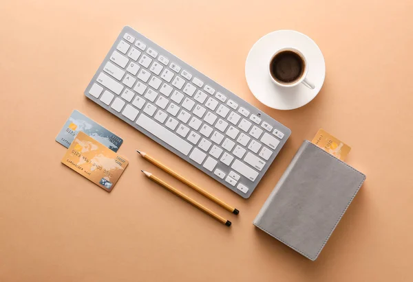 Credit cards with computer keyboard, cup of coffee and stationery on color background. Concept of online banking — Stock Photo, Image