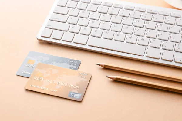 Πιστωτικές κάρτες με πληκτρολόγιο υπολογιστή στο φόντο χρώμα. Έννοια της ηλεκτρονικής τραπεζικής — Φωτογραφία Αρχείου