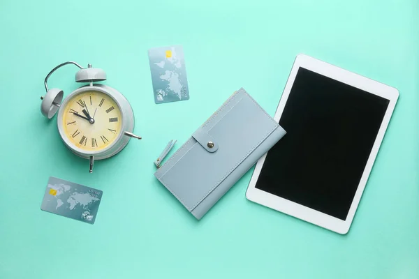 Portfel z tabletem, kartami kredytowymi i budzikiem na tle koloru — Zdjęcie stockowe