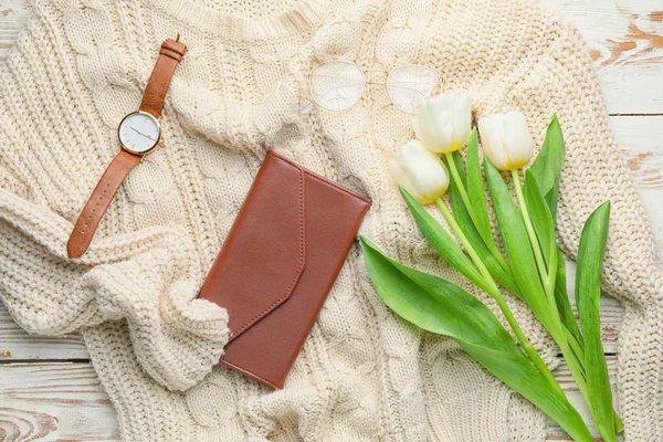Wallet with sweater, clock and flowers on white wooden background — Stock Photo, Image