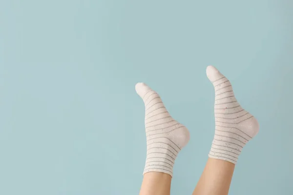 Legs of young woman in socks on color background — Stock Photo, Image