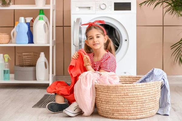 Pequena dona de casa com lavanderia em casa — Fotografia de Stock
