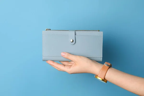 Женская рука с бумажником на цветном фоне — стоковое фото