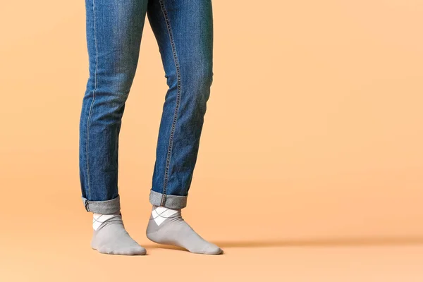 Pernas masculinas em meias e jeans no fundo de cor — Fotografia de Stock