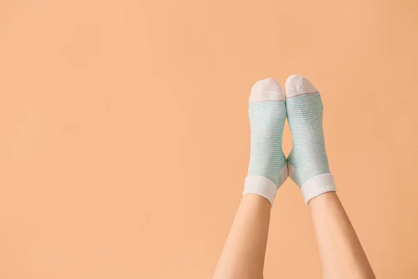 Las piernas de la mujer joven en los calcetines sobre el fondo de color — Foto de Stock