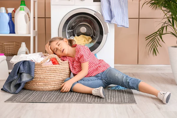 Pequeña ama de casa cansada con lavandería en casa — Foto de Stock