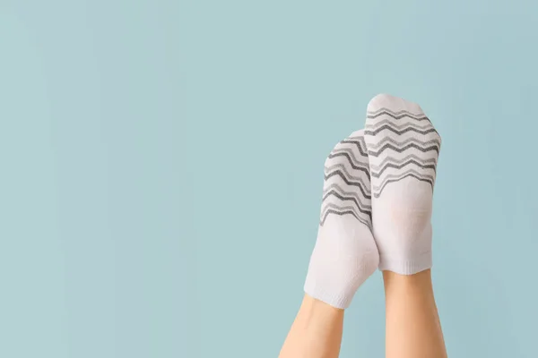 Benen van jonge vrouw in sokken op kleur achtergrond — Stockfoto
