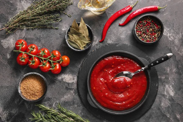 Pfanne mit Tomatensauce und Zutaten auf dunklem Hintergrund — Stockfoto