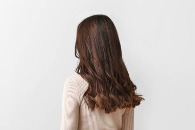 Hafif arka planda güzel saçlı genç kadın