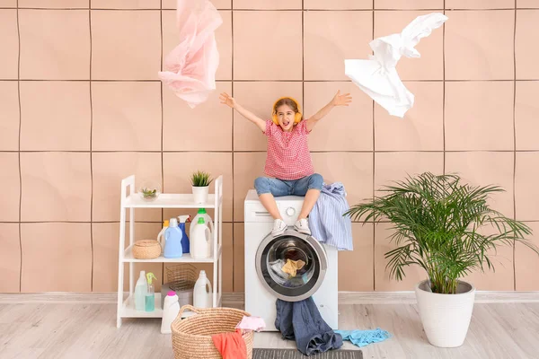 stock image Little housewife listening to music in laundry room