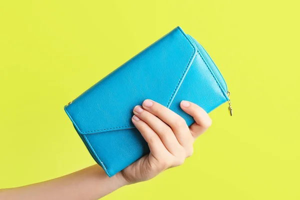 Vrouwelijke hand met portemonnee op kleur achtergrond — Stockfoto