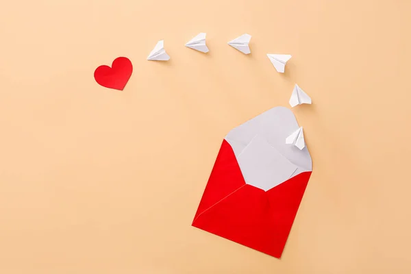 Komposition mit Umschlag, Papierflugzeugen und Herz auf farbigem Hintergrund — Stockfoto