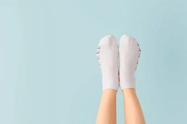 Las piernas de la mujer joven en los calcetines sobre el fondo de color —  Fotos de Stock