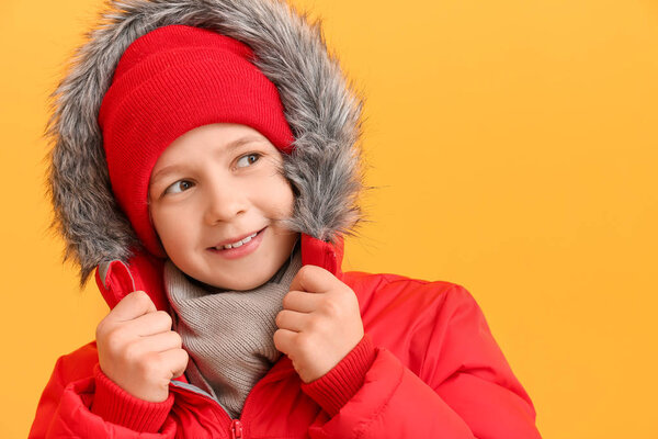 Милый маленький мальчик в зимней одежде на цветном фоне
