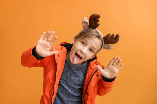Αστείο μικρό αγόρι με κέρατα ελαφιού στο φόντο χρώμα — Φωτογραφία Αρχείου