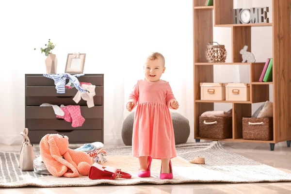 Cute baby girl with female shoes at home — Stock Photo, Image