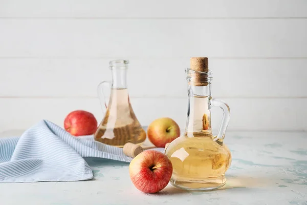 Botellas de vinagre de sidra de manzana sobre mesa blanca — Foto de Stock